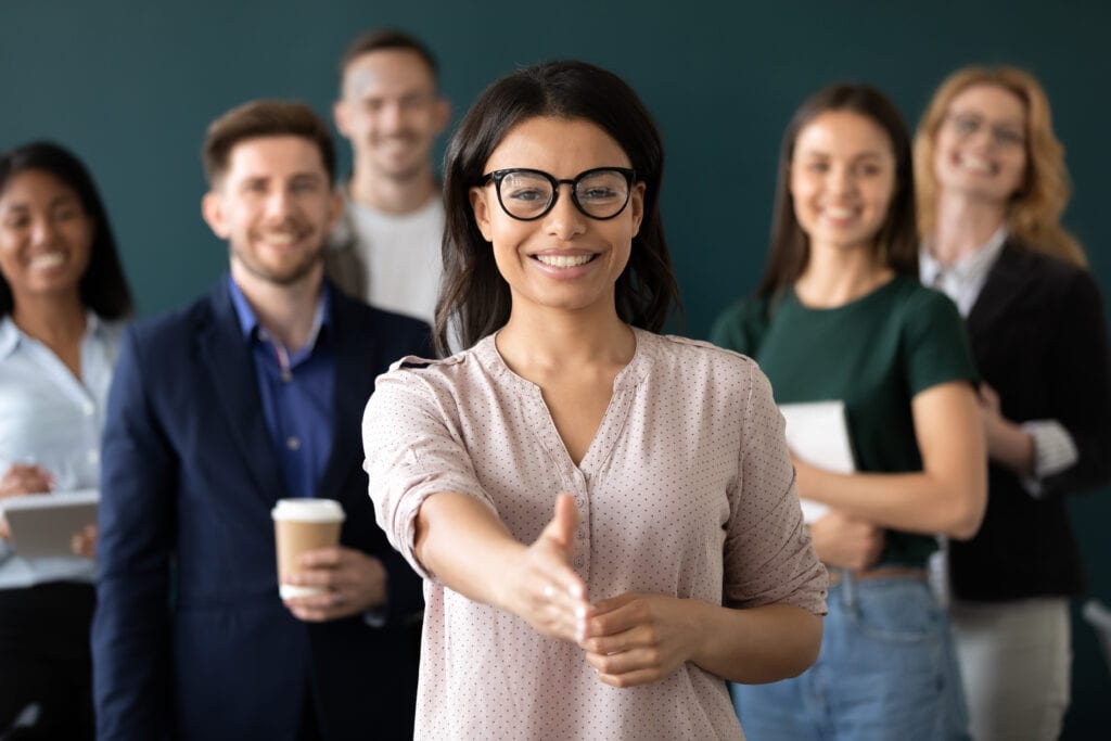 Mixed race woman educator stretch out hand greeting people